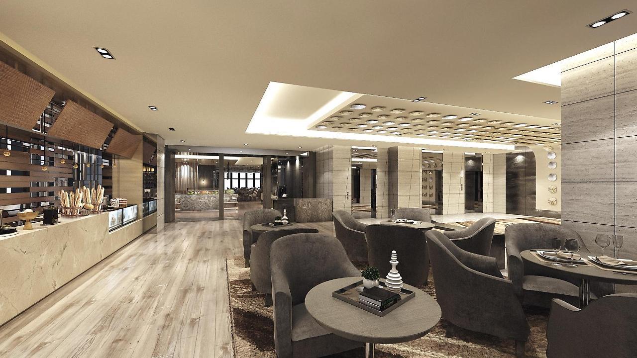 Caesar Metro Taipei Ξενοδοχείο Εξωτερικό φωτογραφία The image shows a modern and stylish interior space, likely a lounge or lobby area. The design features comfortable gray armchairs arranged around circular coffee tables. The flooring is made of light wood, contributing to a warm and inviting atmosph